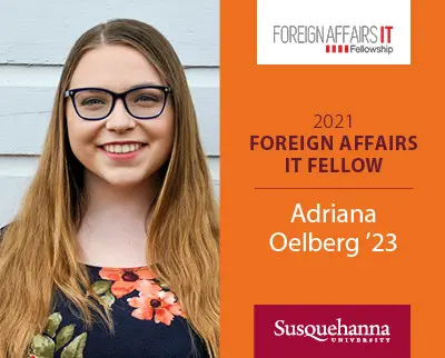 A young woman with long hair and glasses smiles in front of a gray wall. The text reads: "2021 Foreign Affairs IT Fellow, Adriana Oelberg '23, Susquehanna University" with a logo for the Foreign Affairs IT Fellowship.